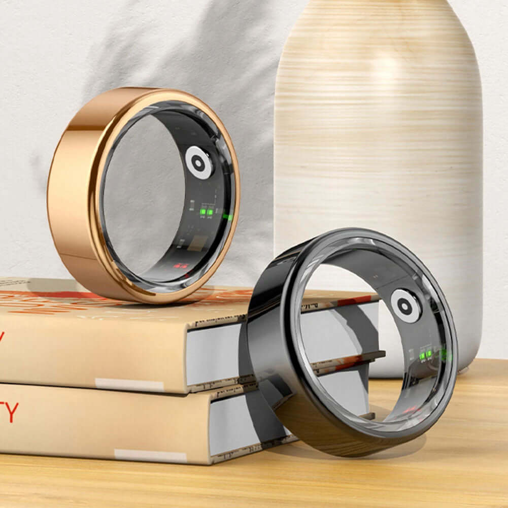 Smart Ring - Transform Your Fitness Journey displayed in metallic gold and black on stacked books.