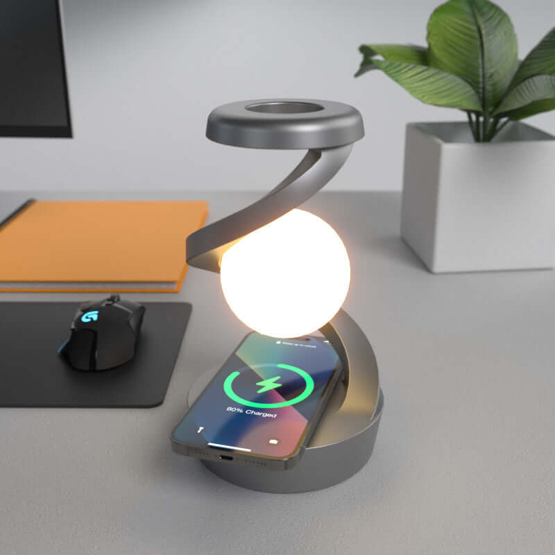 Levitating Ball Lamp with Wireless Charger illuminating a modern workspace with a smartphone charging on its base.